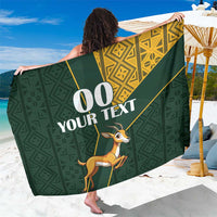 Green sarong with gold geometric kente border and springbok jumping print