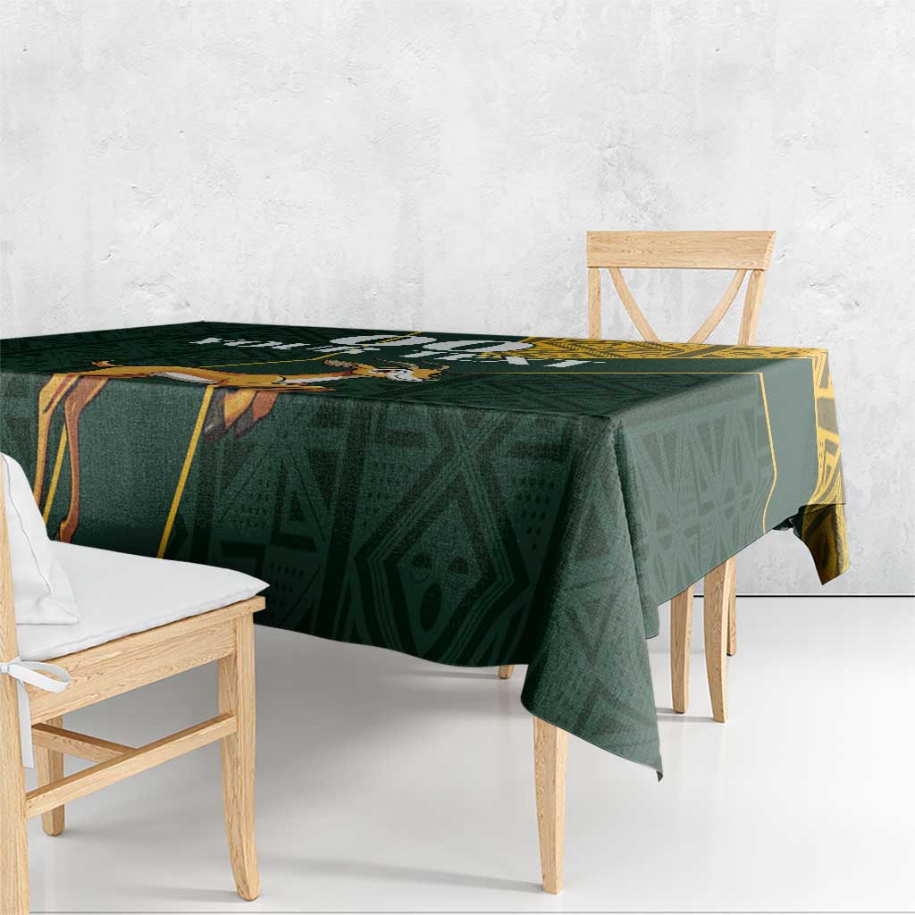 Green tablecloth with yellow geometric trim and jumping springbok graphic