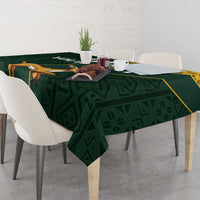Green tablecloth with yellow border and springbok jumping motif across the center