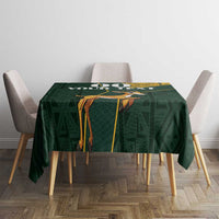 Green tablecloth with Kente-style yellow frame and jumping springbok illustration