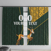 Green window curtains with springbok graphic and yellow geometric Kente-style pattern
