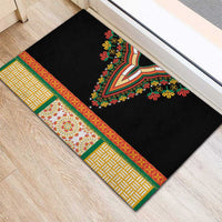 Black doormat with striped green and yellow border and V-shaped floral embroidery
