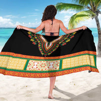 Black sarong laid flat with wide embroidered V motif, colorful geometric border trim