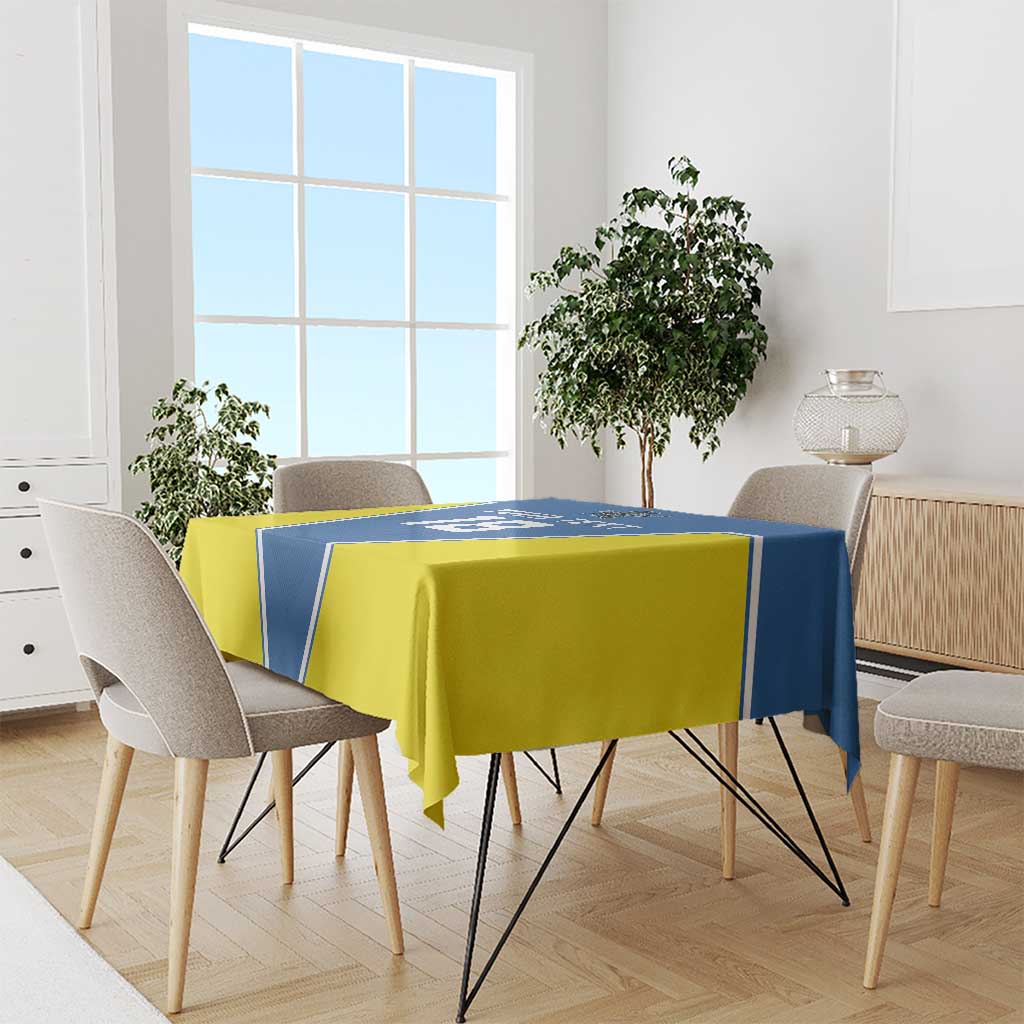 Blue and yellow tablecloth draped over dining table, shown in a room