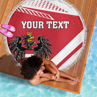 Red-and-white round beach blanket with fringe and “Your Text” over black coat of arms