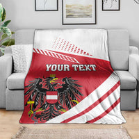 Personalized throw blanket on couch with red/white stripes, black crest, and 'YOUR TEXT'