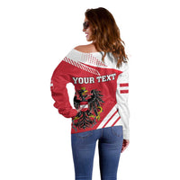 Women’s off-shoulder sweater with red/white flag print and crest, side/back view