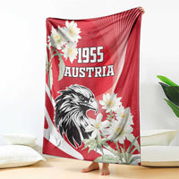 Red Austria blanket draped on floor with black eagle, white flowers, and “1955”