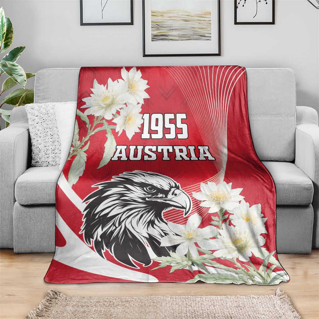Red Austria blanket over gray sofa with black eagle graphic and white edelweiss flowers