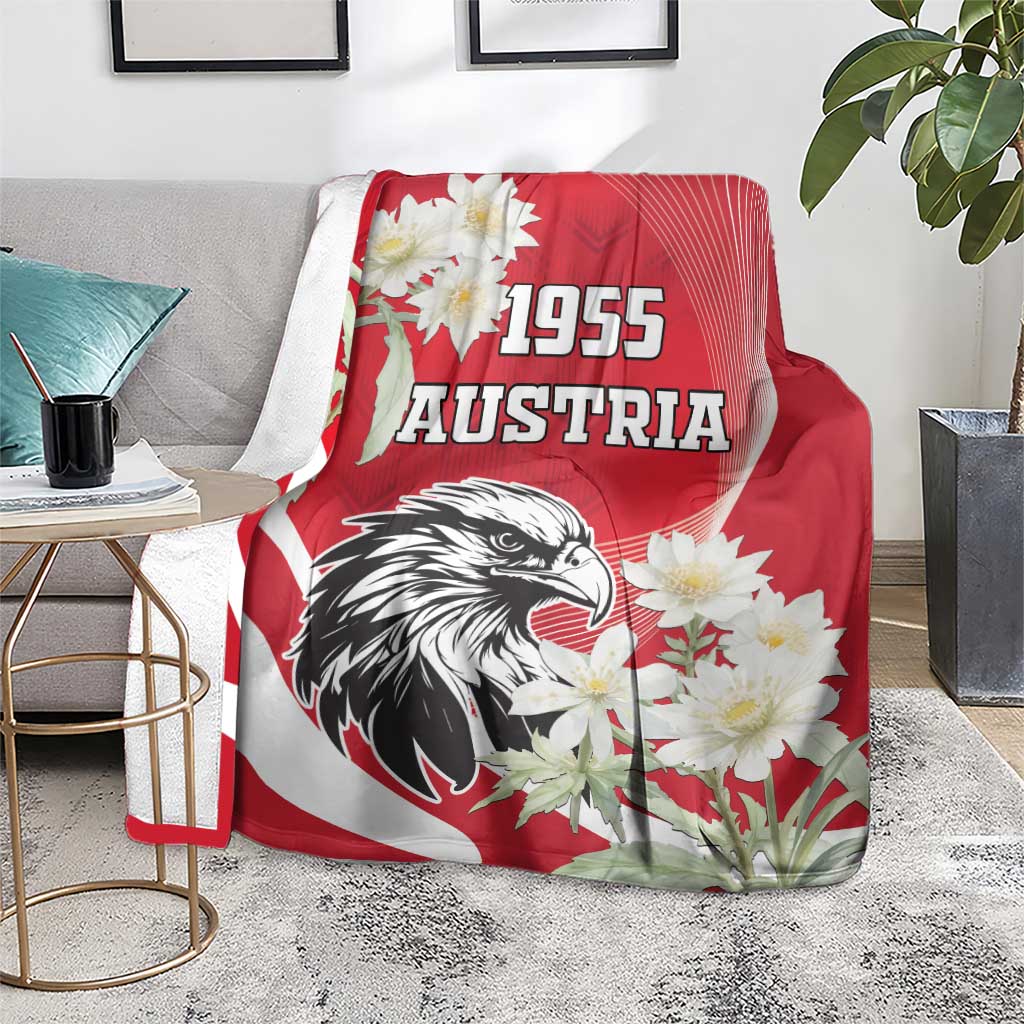 Red Austria blanket on gray couch with eagle artwork, “1955” lettering, and white flowers