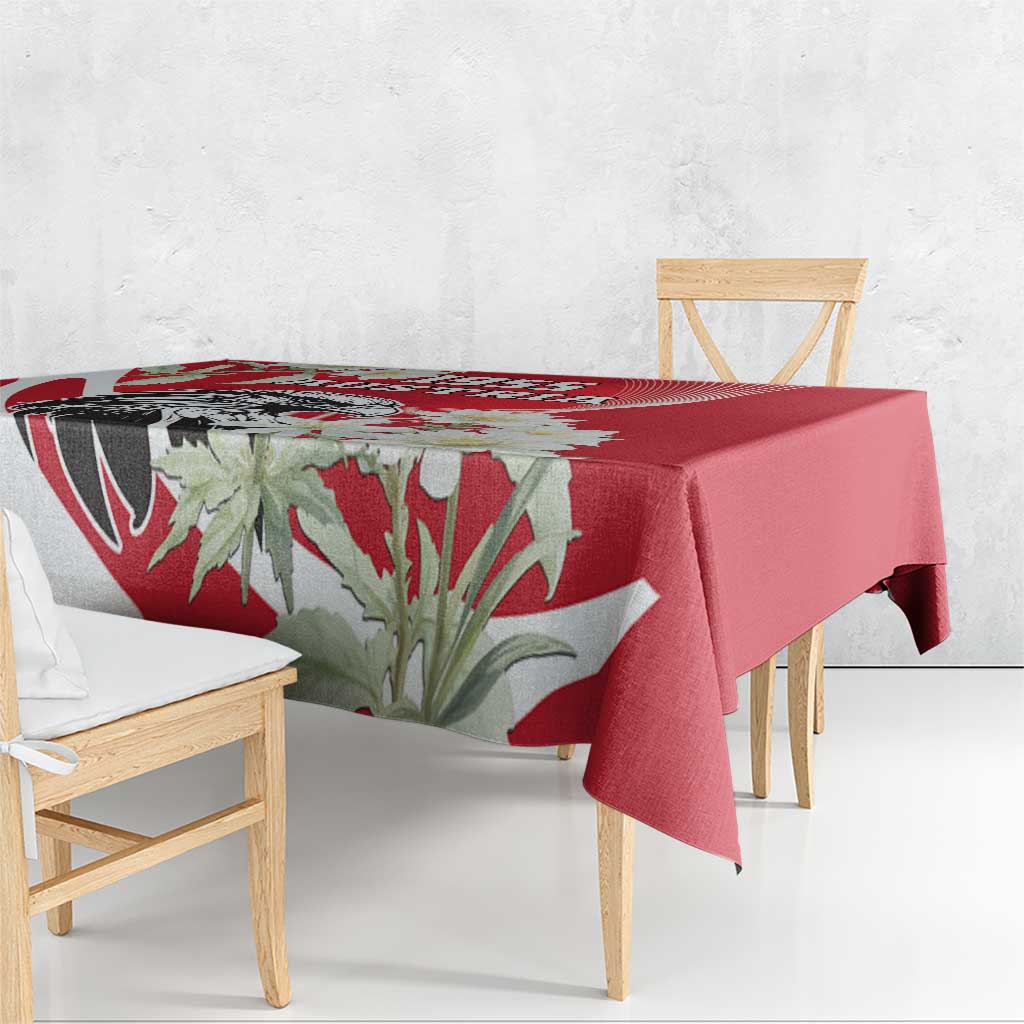 Red tablecloth with floral leaves and bold graphic band, draped over table