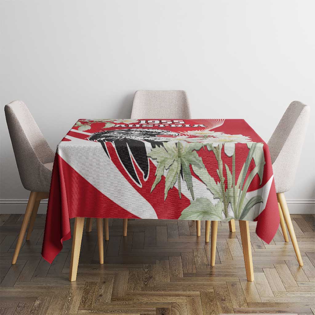 Red tablecloth with eagle and white flower print, on round table with chairs