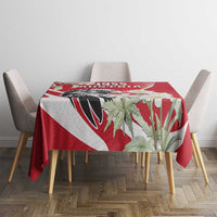 Red tablecloth with eagle and white flower print, on round table with chairs