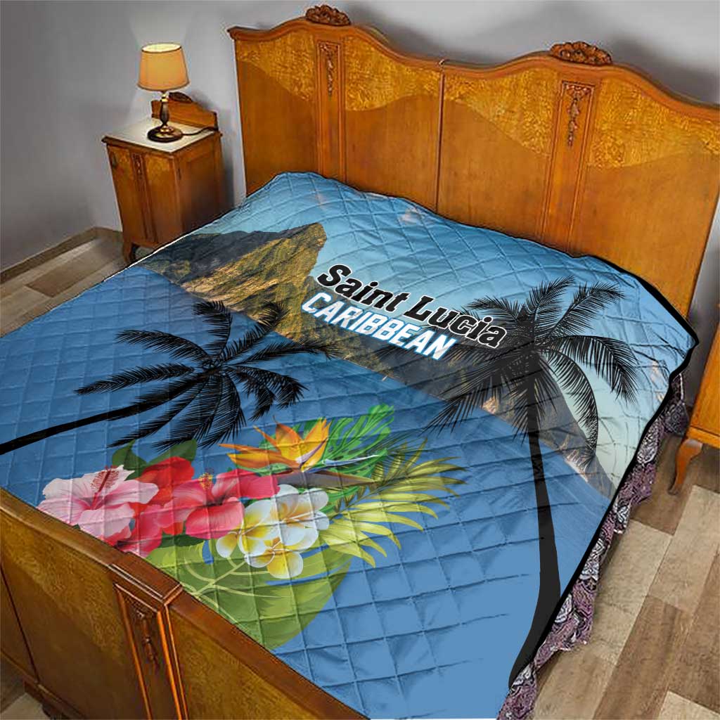 Blue quilt laid on bed with mountain print, palm trees, hibiscus flowers, and 'Saint Lucia Caribbean'