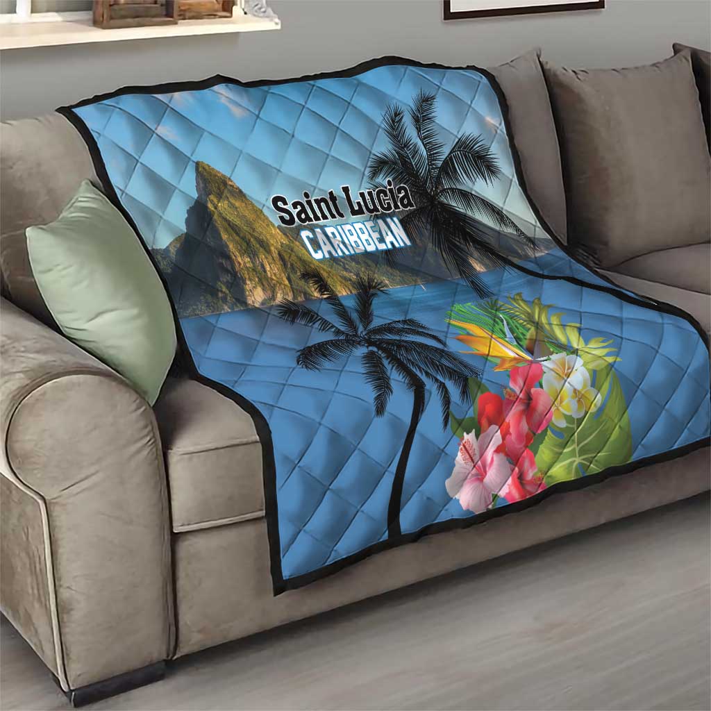 Blue tropical quilt on couch with palm trees, hibiscus flowers, and 'Saint Lucia Caribbean' lettering