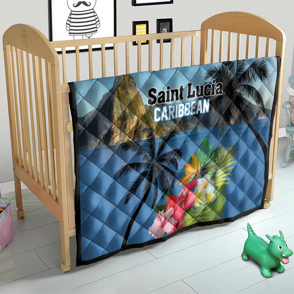Blue quilt on crib with palm trees, mountain print, hibiscus flowers, and 'Saint Lucia Caribbean'