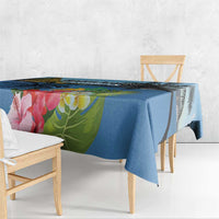 Blue hibiscus and palm leaf tablecloth draped over a dining table