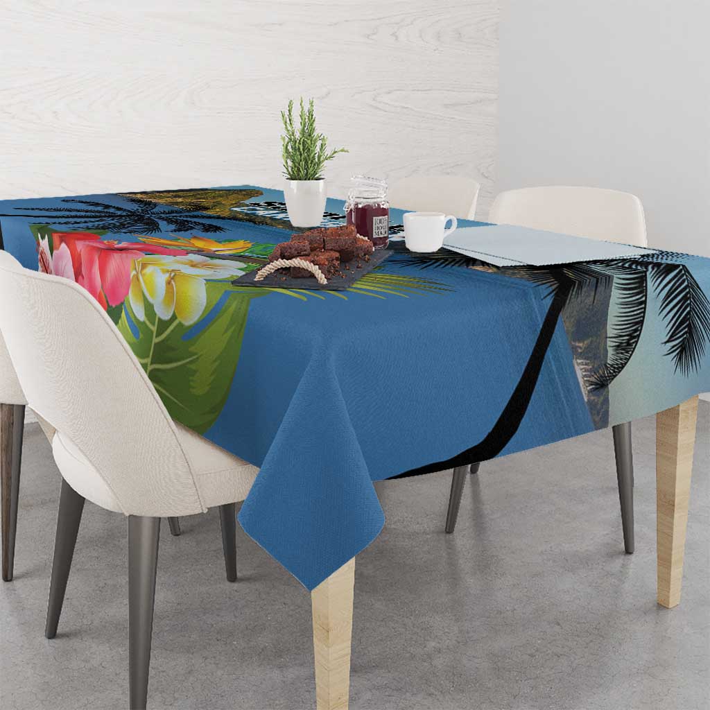 Blue tablecloth with hibiscus flowers and palm leaves, draped across dining table