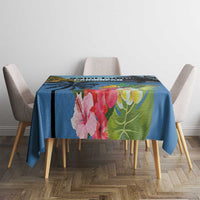 Blue tropical tablecloth with hibiscus blossoms and green foliage on dining table
