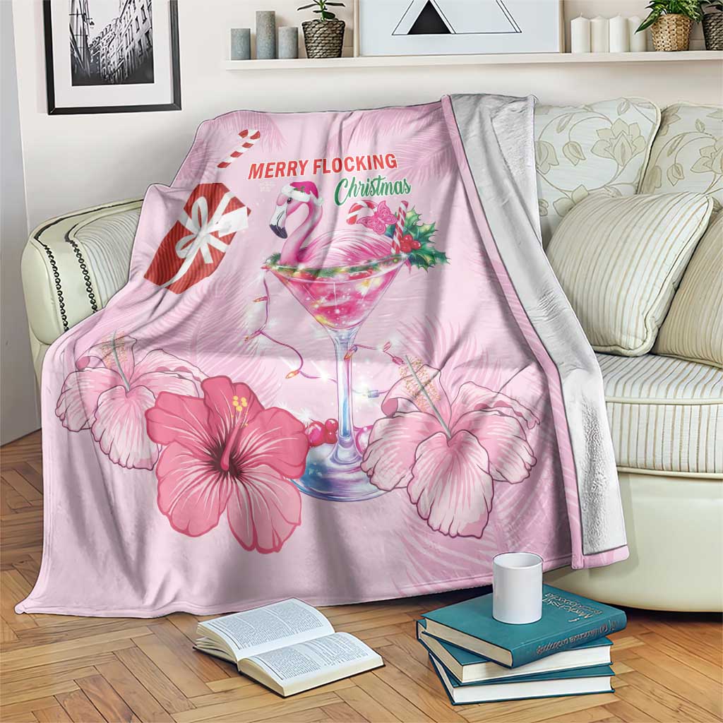 Pink flamingo Christmas blanket on bed with hibiscus flowers and colorful drink graphic