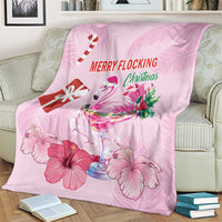 Pink flamingo Christmas blanket on sofa with candy cane, drink glass, and hibiscus flowers