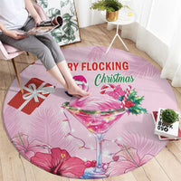 Pink round Christmas carpet with flamingo in martini glass, red gift, and 'MERRY FLOCKING' text