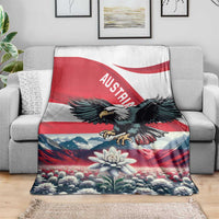 Black eagle and Austria flag blanket draped on a gray sofa with floral mountain print