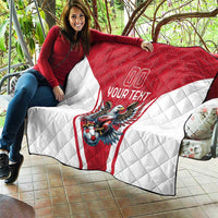 Red and white quilt laid across couch with eagle mascot and “Your Text”