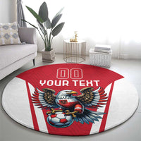 Round football carpet with eagle mascot holding soccer ball, red-and-white striped design