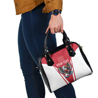 Red, white, and black shoulder handbag with eagle mascot graphic and black top handles