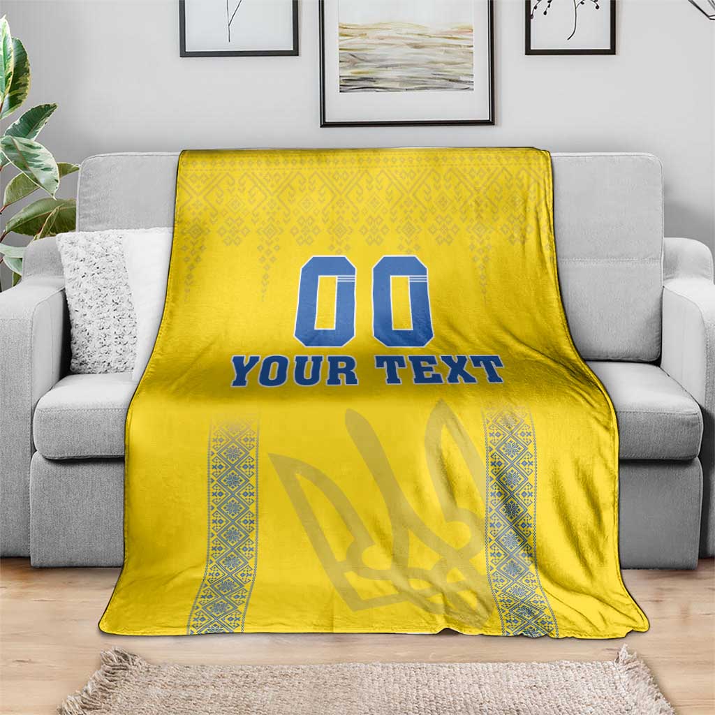 Yellow throw blanket with blue “00” and “YOUR TEXT” design and patterned vertical border