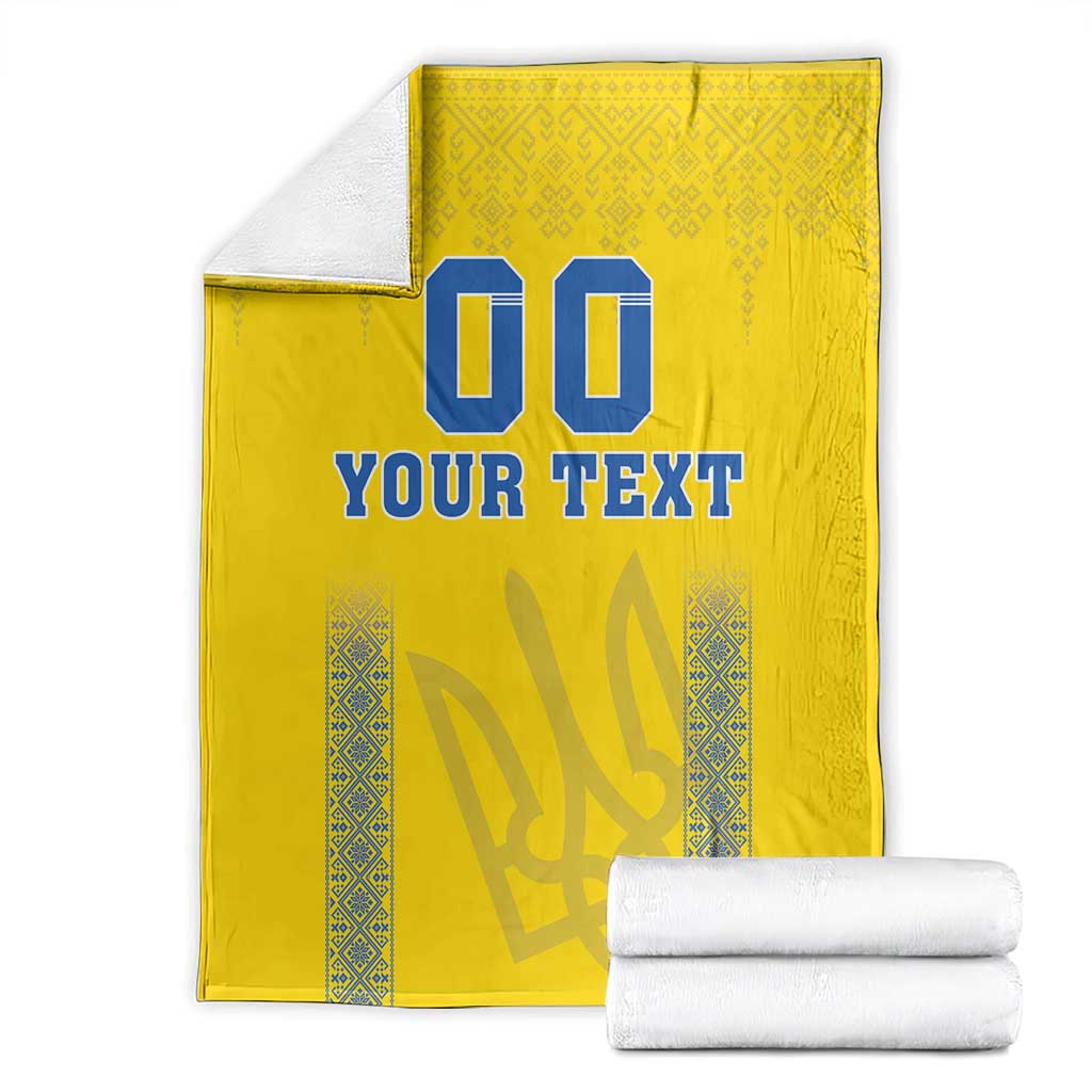 Yellow blanket folded with blue “00” and “YOUR TEXT” and patterned border stripe