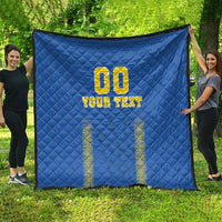 Folded blue football-style quilt blanket with diamond pattern and yellow "YOUR TEXT"