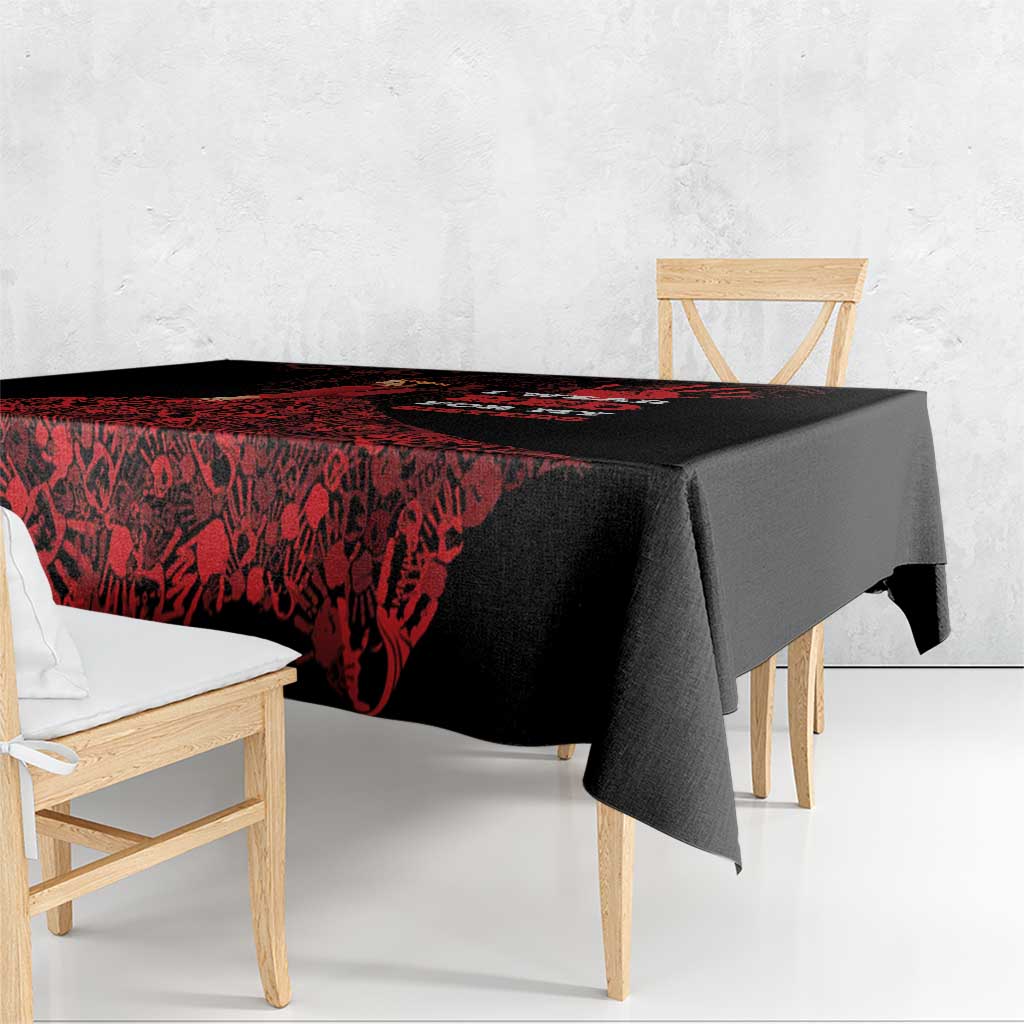 Black tablecloth with red print and overhanging corners on a dining table