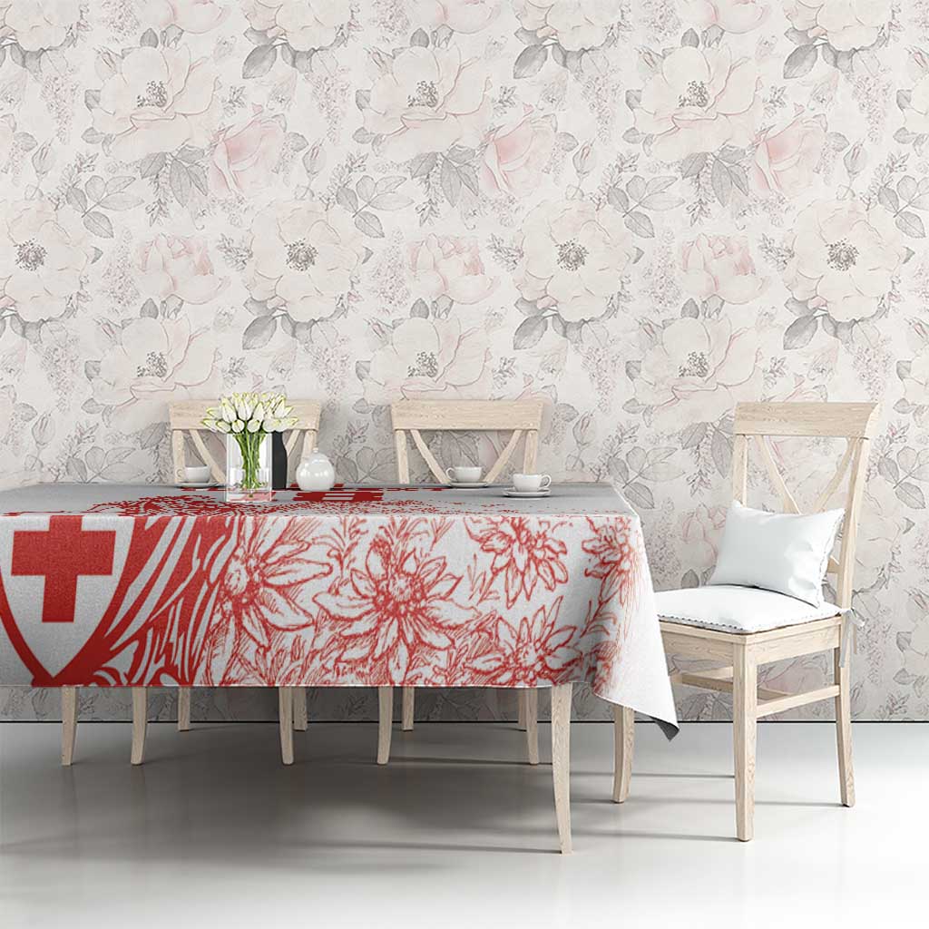 White tablecloth with red Swiss-style cross and floral print on a long table
