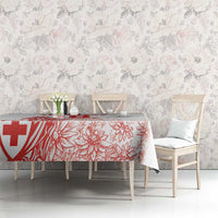 White tablecloth with red Swiss-style cross and floral print on a long table