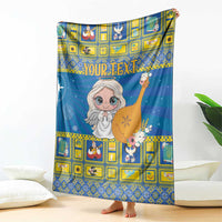 Blue and yellow Christmas blanket draped on couch with angel holding a nativity star