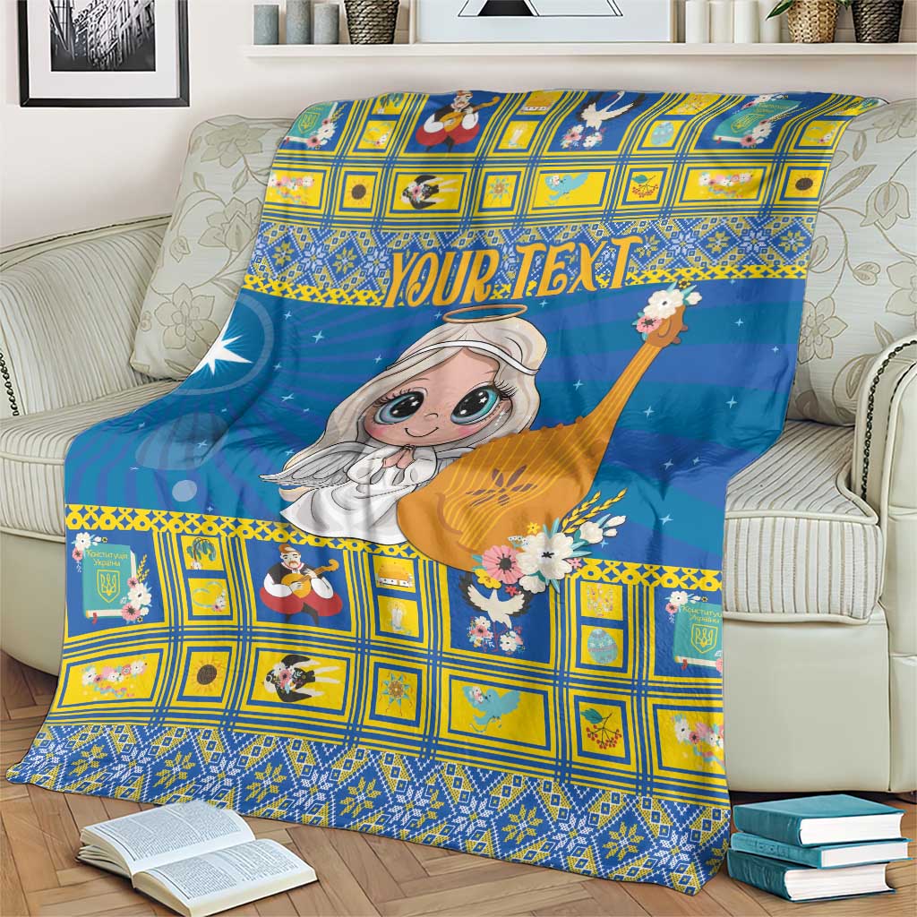 Blue Christmas blanket featuring angel detail with floral accents, draped on sofa