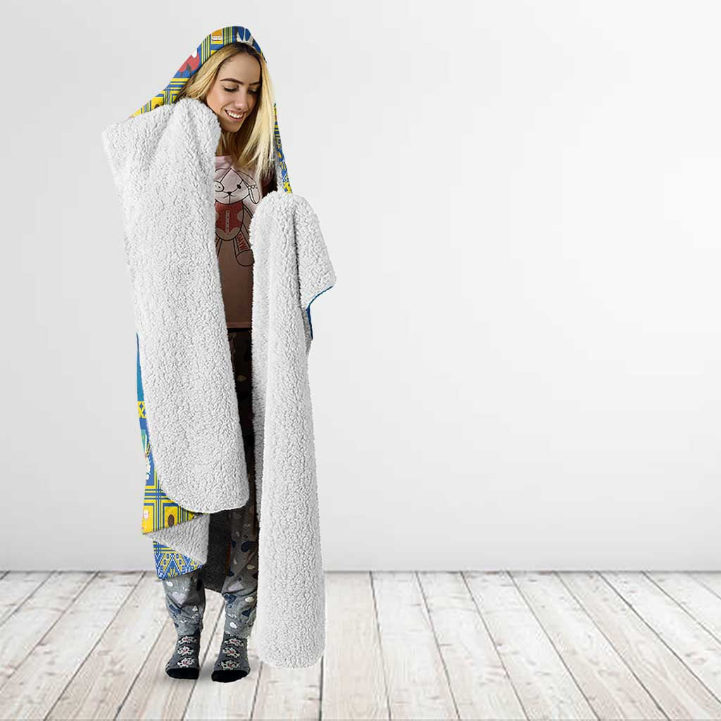 Blue hooded blanket with sherpa hood, star-and-angel design, worn with patterned pants