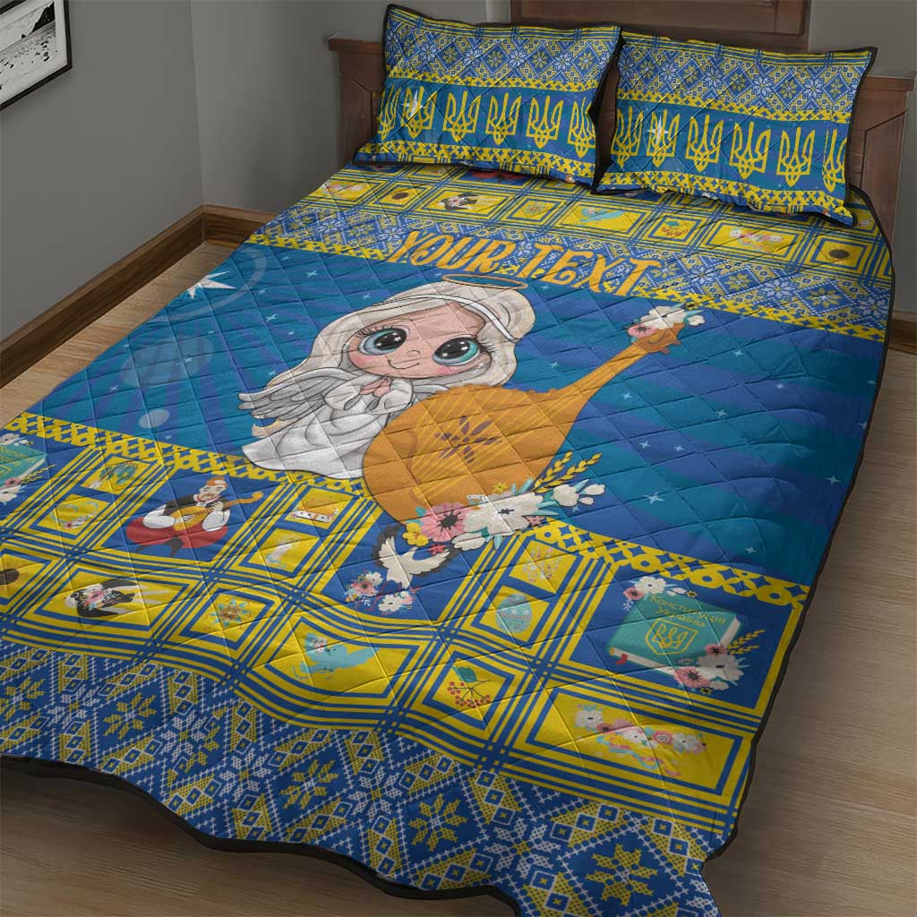 Blue and yellow quilt bed set showing cartoon angel figure, geometric border, and two pillows
