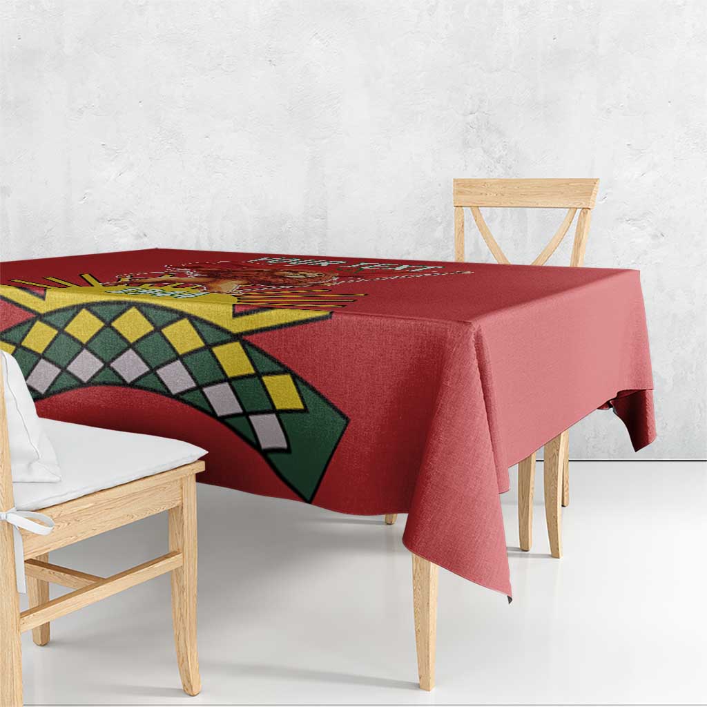 Red tablecloth corner showing lion graphic and green-yellow geometric pattern