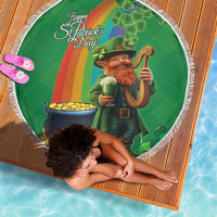 Round green beach blanket with white fringe, leprechaun with beer and cauldron of gold.