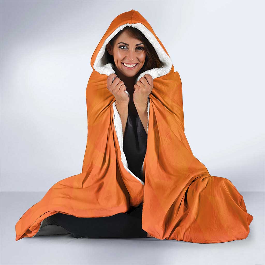 Orange hooded blanket with white fleece lining, worn with hood up