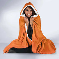 Orange hooded blanket with white fleece lining, worn with hood up