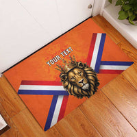 Orange rubber doormat featuring crowned lion and Dutch flag diagonal stripes, 'YOUR TEXT'.
