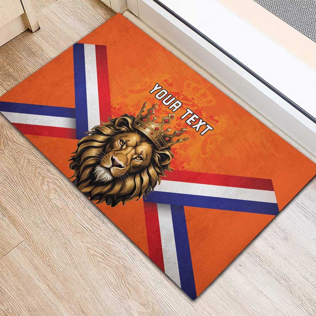 Orange rubber doormat with crowned lion and Dutch flag stripes, 'YOUR TEXT' centered.