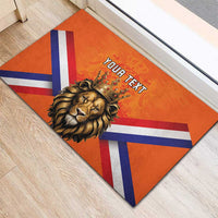 Orange rubber doormat with crowned lion and Dutch flag stripes, 'YOUR TEXT' centered.