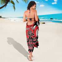 Red and black sarong with eagle-style 'Your Text' print, worn