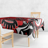 Red patterned tablecloth draped over dining table with eagle-style artwork