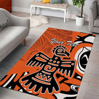 Orange area rug with bold eagle-style graphic in black and white